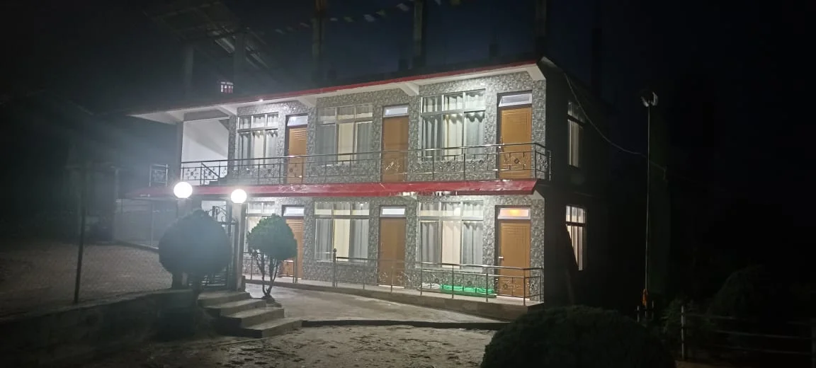 Rishabh Rich Homestay - Night Facade with Illuminated Globe Lamps